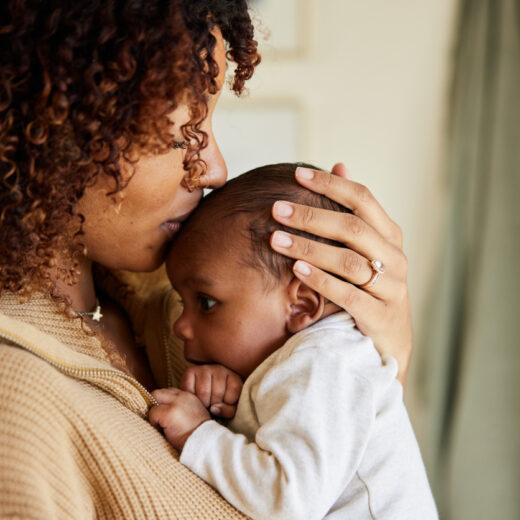 A woman is holding her baby in her arms.